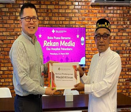 Hospital Director Eka Hospital Pekanbaru, dr Widy Hartono MARS saat menyerahkan bantuan untuk Masjid Al Iman.(foto: istimewa)