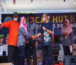 Gubri H. Syamsuar menyerahkan hadiah utama Puncak HUT ke-47 SMA Negeri 8 Pekanbaru kepada majelis guru dan petugas administrasi sekolah yang beruntung