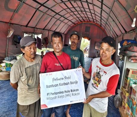 Darmalis bersama warga terharu menerima bantuan bahan makanan pokok bagi korban banjir dari PT PHR WK Rokan (foto/int)