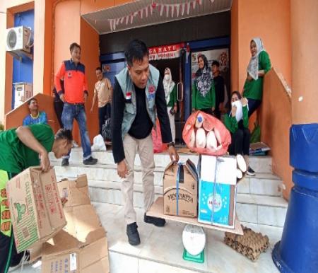 Kalaksa BPBD Pekanbaru, Zarman Chandra menimbang sampah anorganik milik personel yang akan disetor ke bank sampah.(foto: rahmat/halloriau.com)