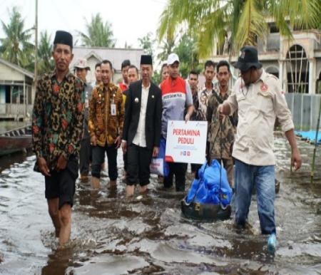 Comrel & CID PHR Zona 1, Nurseno Dwi Putranto bersama Bupati Rohil, Afrizal Sintong saat mengunjungi korban banjir di Kepenghuluan Rantau Bais.(foto: afrizal/halloriau.com)