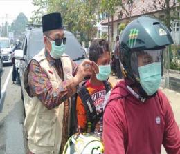  Kepala BPBD Rohul, ikut membagikan masker gratis ke pengendara di jalan raya kawasan Taman Kota, Pasir Pangaraian.