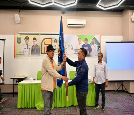 Plt Ketua PWI Riau, Raja Isyam Azwar menyerahkan bendera Pataka kepada Ketua PWI Dumai terpilih periode 2023-2026 Bambang Prayetno (foto/ist)