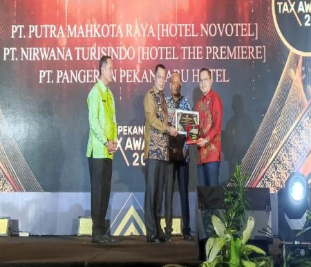 Pj Walikota Pekanbaru Muflihun berikan penghargaan ke dunia usaha dalam acara Pekanbaru Tax Award 2023 (foto/rahmat)