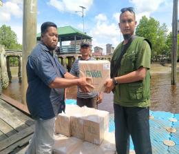 Partner Lapangan BWA di Kepulauan Meranti, Ustadz Fefen saat menyerahkan bantuan Al Qur