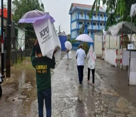 Petugas TPS sedang menyiapkan logistik Pemilu meski hujan turun (foto/nuonline)