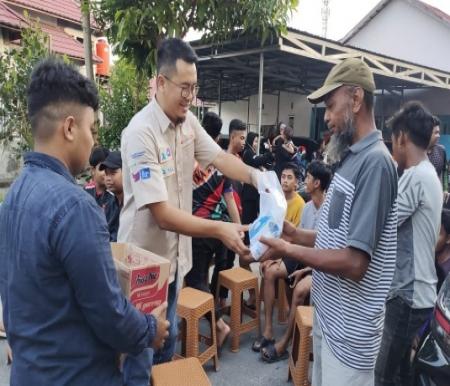 Head of Sales XL Axiata area Kalimantan Selatan dan Kalimantan Tengah, Hurry Amar Sidqi (tengah) menyerahkan bantuan (foto/ist)