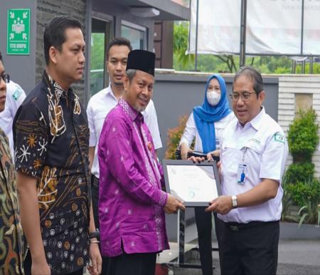 Asisten I Setdaprov Riau, Masrul Kasmy menerima sertifikat dari BPJS Kesehatan Divisi Regional II (foto/int)