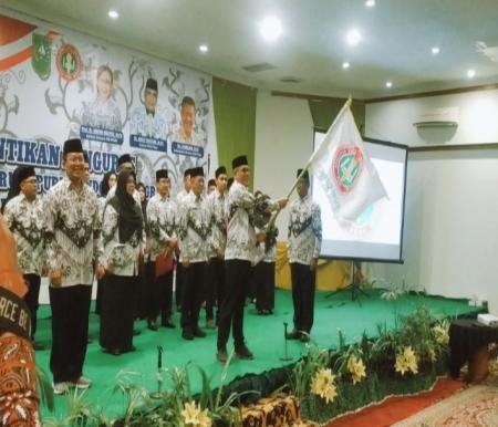 Ketua Dr Adolf Bastian mengibarkan bendera PGRI Riau saat pelantikan pengurus di Hotel Mutiara Merdeka, Pekanbaru (foto/riki)