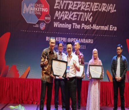 Vice Director PT KJU Group, Ricky W Anwar saat menerima penghargaan dari MarkPlus Corp (MCorp) melalui IMC 2023. (foto: istimewa)