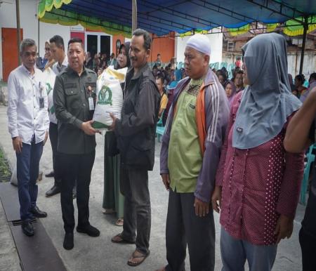 Asisten I Setdaprov Riau saat menyerahkan beras bantuan untuk korban banjir.(foto: mcr)