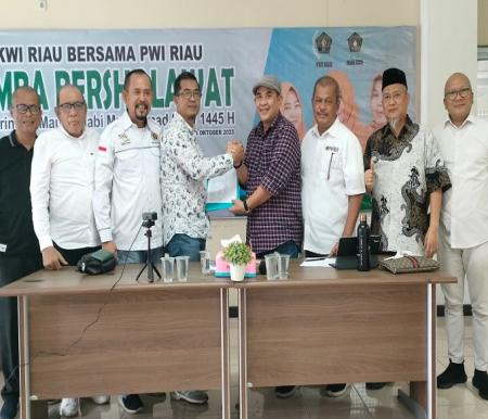 Ketua Bidang Organisasi PWI Pusat, Zulmansyah Sekedang menyerahkan hasil rapat pleno kepada Raja Isyam Azwar, Plt Ketua PWI Riau, Rabu (1/11/2023). Foto budy