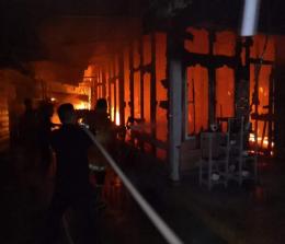 Terlihat personil Damkar memadamkan api yang membakar rumah di Desa Alah Air, Selasa (14/6/2022) malam. 