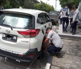 Petugas Dishub Pekanbaru mengembosi kendaraan yang melanggar aturan (foto/Rahmat)