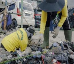 Petugas kebersihan mengeruk sampah dari drainase Jalan Pangeran Hidayat (foto/int)