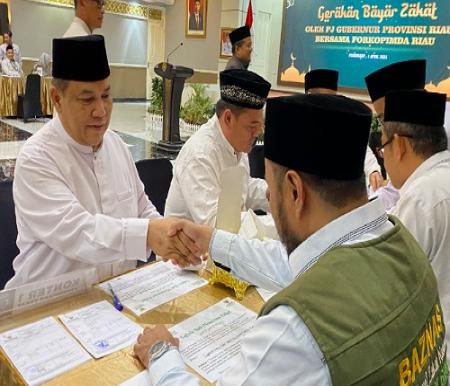 Pj Gubernur Riau, SF Hariyanto saat membayar zakat.(foto: sri/halloriau.com)