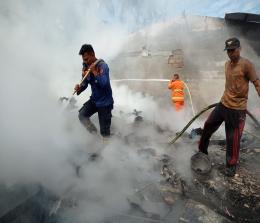 Tim Damkar RAPP dan Pemkab Pelalawan saat memadamkan kebakaran rumah di Simpang Perak.(foto: andi/halloriau.com)