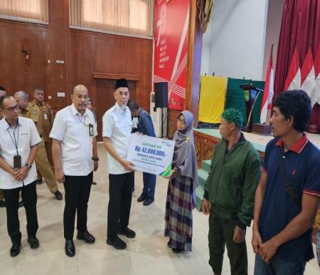 Wali Kota Dumai H Paisal menyerahkan kartu BPJS Ketenagakerjaan kepada pekerja rentan di Kota Dumai (foto/bambang)
