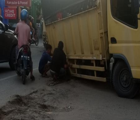 Mobil truk terpuruk dibekas galian SPAM PDAM Tirta Siak, Jalan Durian Pekanbaru yang tak ditimbun dengan baik.(foto:rivo/halloriau.com)