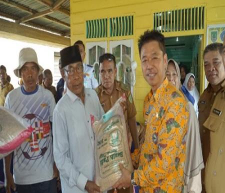 Bupati Rohil, Afrizal Sintong memberikan bantuan benih padi untuk petani.(foto: afrizal/haloriau.com)