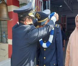 Kepala Rutan Kelas IIB Rengat, Julius Barus SE MH mengalungkan bungan kepada Zailani yang masuki purna tugas.(foto: andri/hallroiau.com)