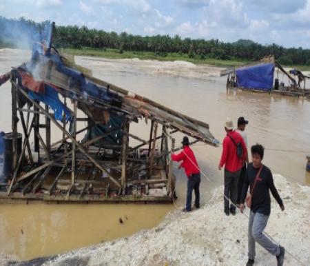 Personel Polsek Singhil merusak rakit PETI dalam kegiatan razia di Desa Tanjung Pauh.(foto: ultra/halloriau.com)