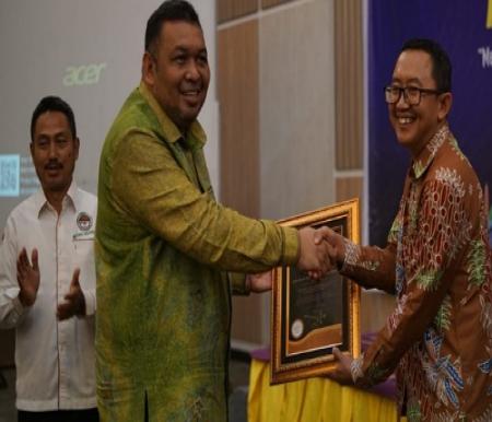Kepala Divisi KUKM BPDPKS, Helmi Muhansyah menerima penghargaan dari Dirjen Perkebunan, Andi Nur Alam Syah.(foto: bayu/halloriau.com)