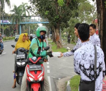 Anggota PGRI Riau menggelar aksi sosial berbagi paket berbuka puasa di Pekanbaru (foto/ist)