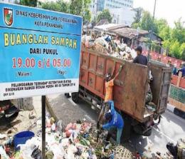Petugas sedang membersihkan sampah di Pekanbaru (foto/int)