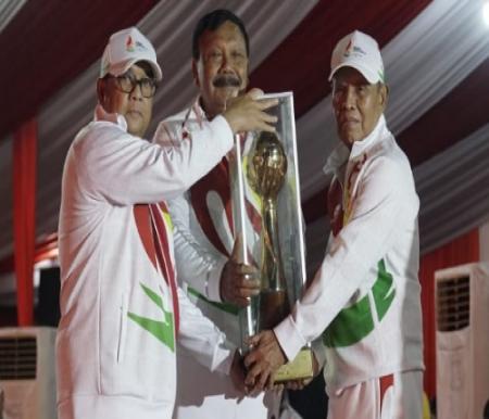 Plt Gubernur Riau, Edy Natar Nasution menerima Piala Juara Umum Porwil Sumatera XI 2023 yang diserahkan Wakil Ketua I KONI Pusat, Suwarno.(foto: rahmat/halloriau.com)