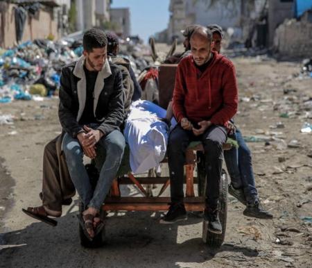 Warga membawa jenazah seorang warga Palestina tewas dalam insiden dini hari ketika warga bergegas menuju truk bantuan di Kota Gaza pada 29 Februari 2024. Foto: AFP