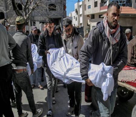 Warga membawa jenazah korban tewas dalam insiden dini hari ketika warga bergegas menuju truk bantuan di Kota Gaza pada 29 Februari 2024. Foto: AFP